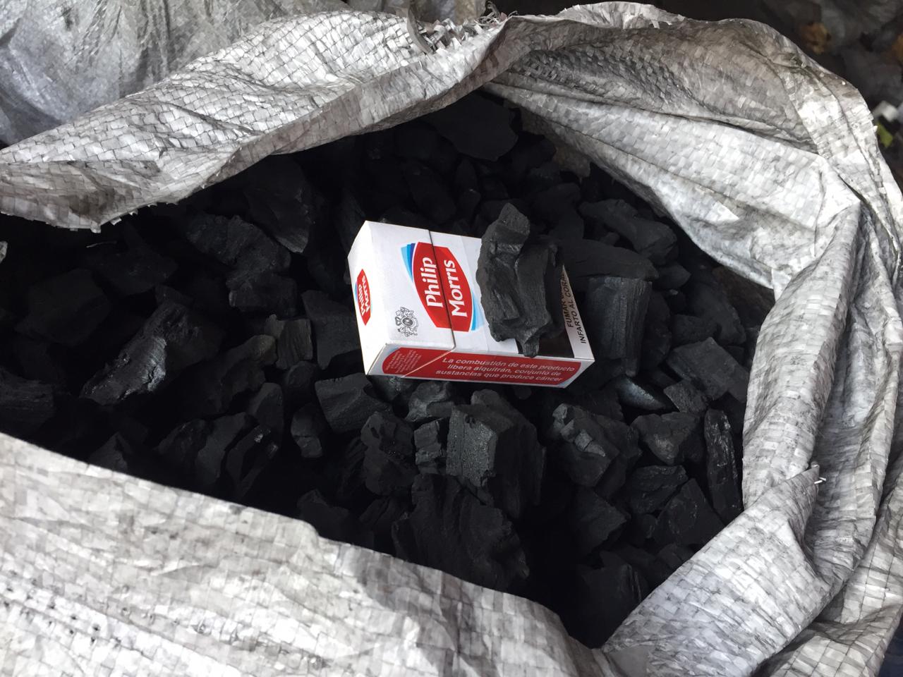 Shisha-grade white quebracho charcoal in a bag, with a cigarette pack for size